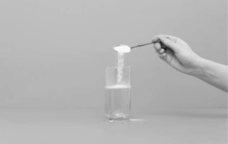 A closer look at what is the agglomeration process by looking at a hand pouring powder into water